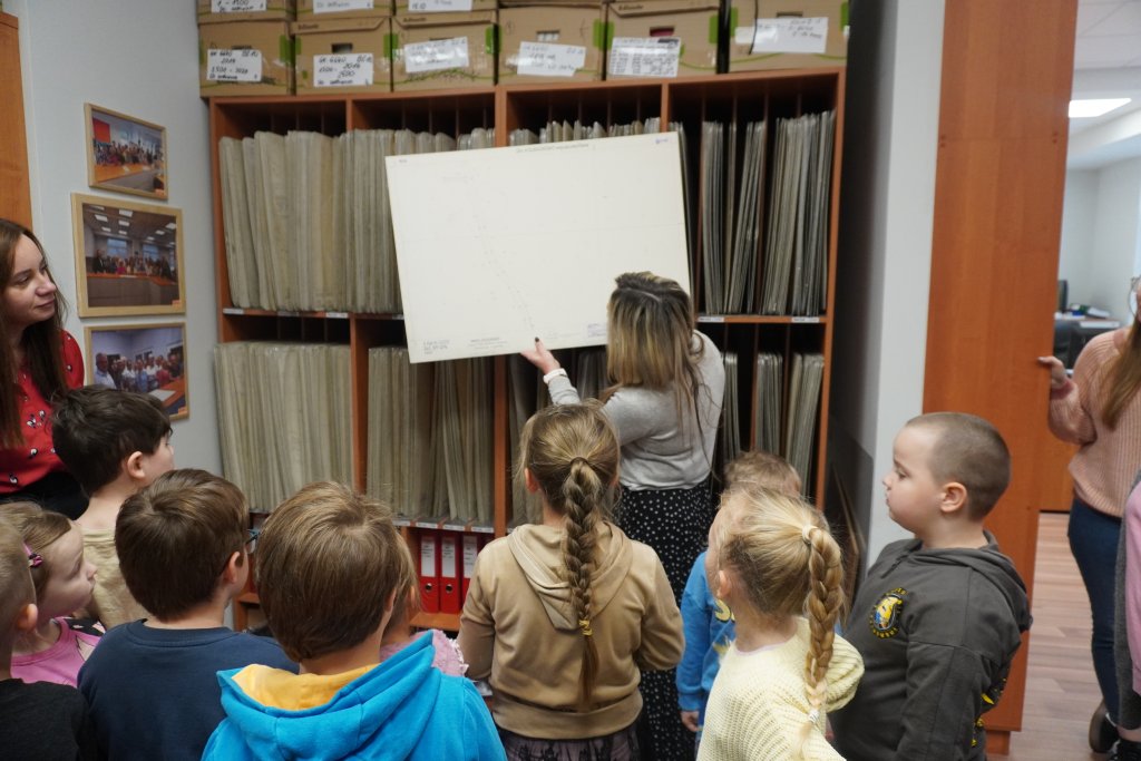 Dzieci oglądają mapy w Wydziale Geodezji, Kartografi i Katastru Starostwa Powiatowego w Policach